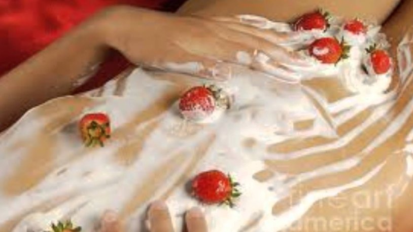 Strawberries with cream on the body of a girl