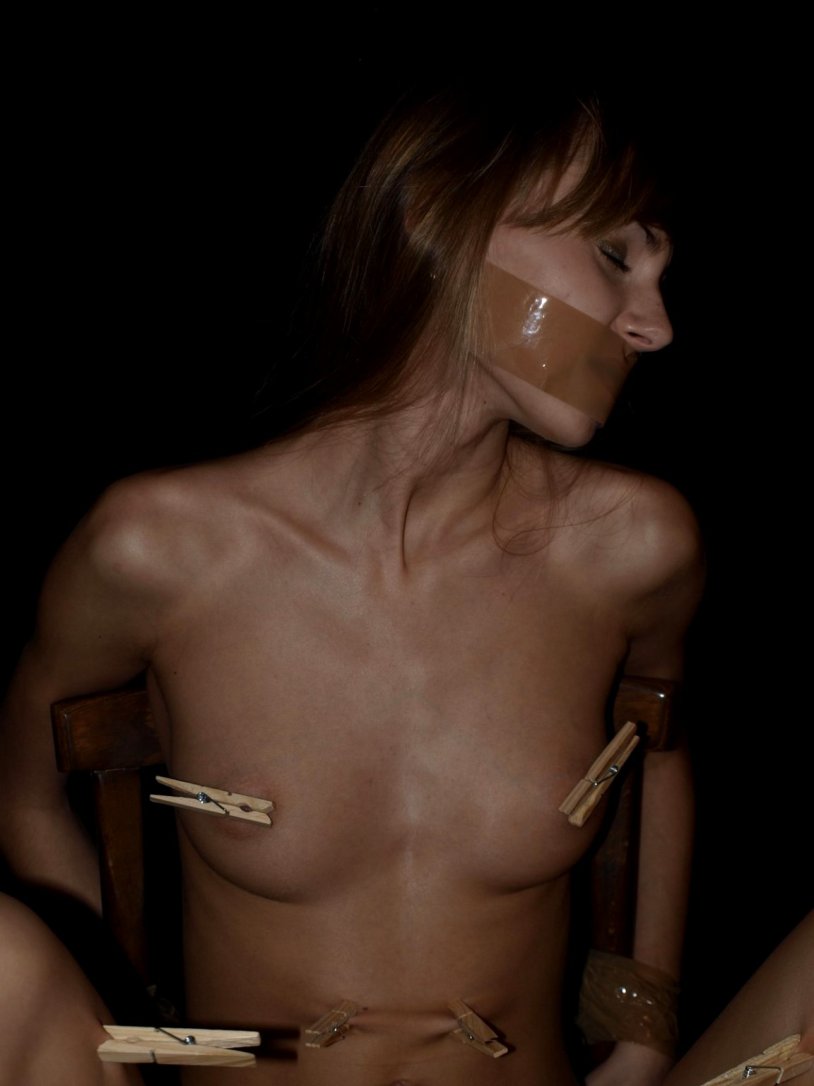 The girl is suspended by the legs of BDSM