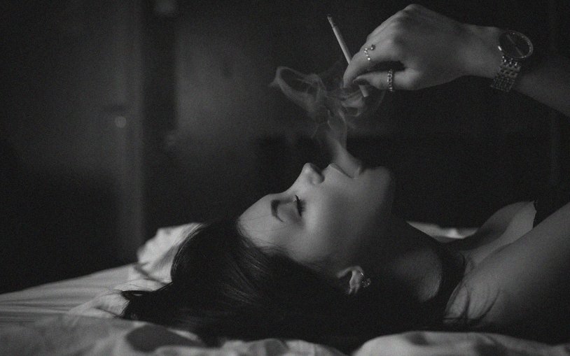 Girl with a cigarette in bed