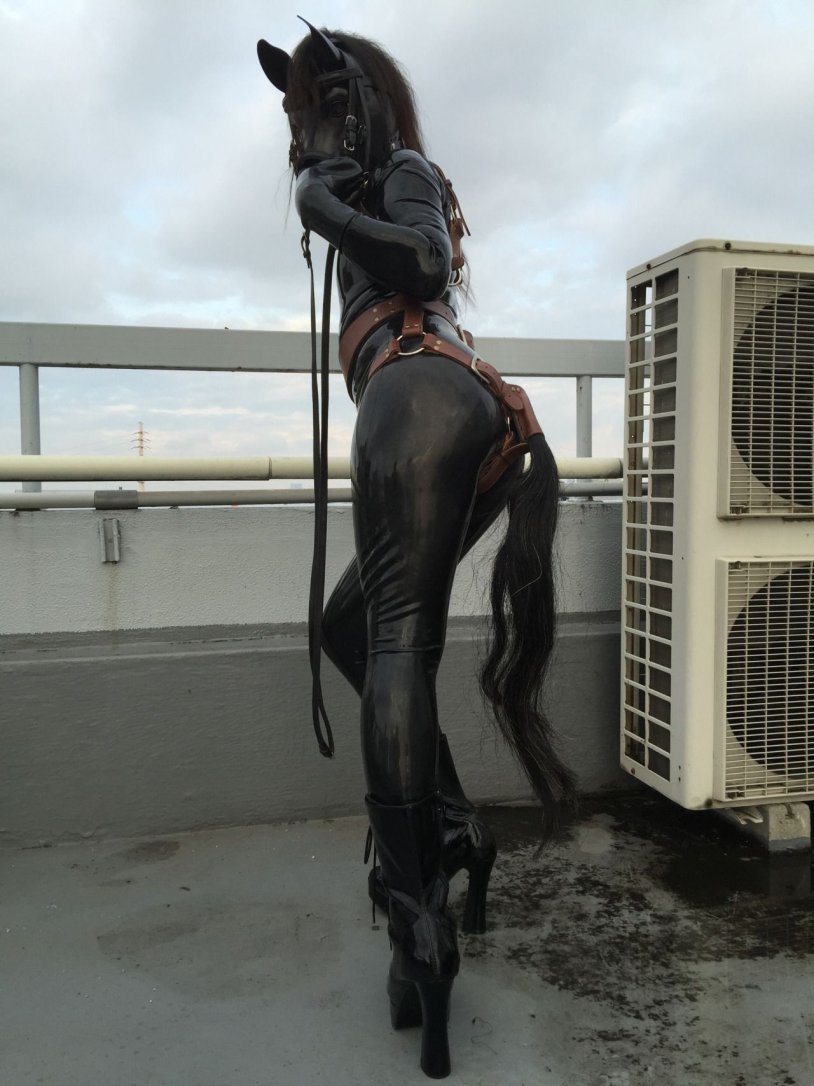 Girl in a costume of horse latex