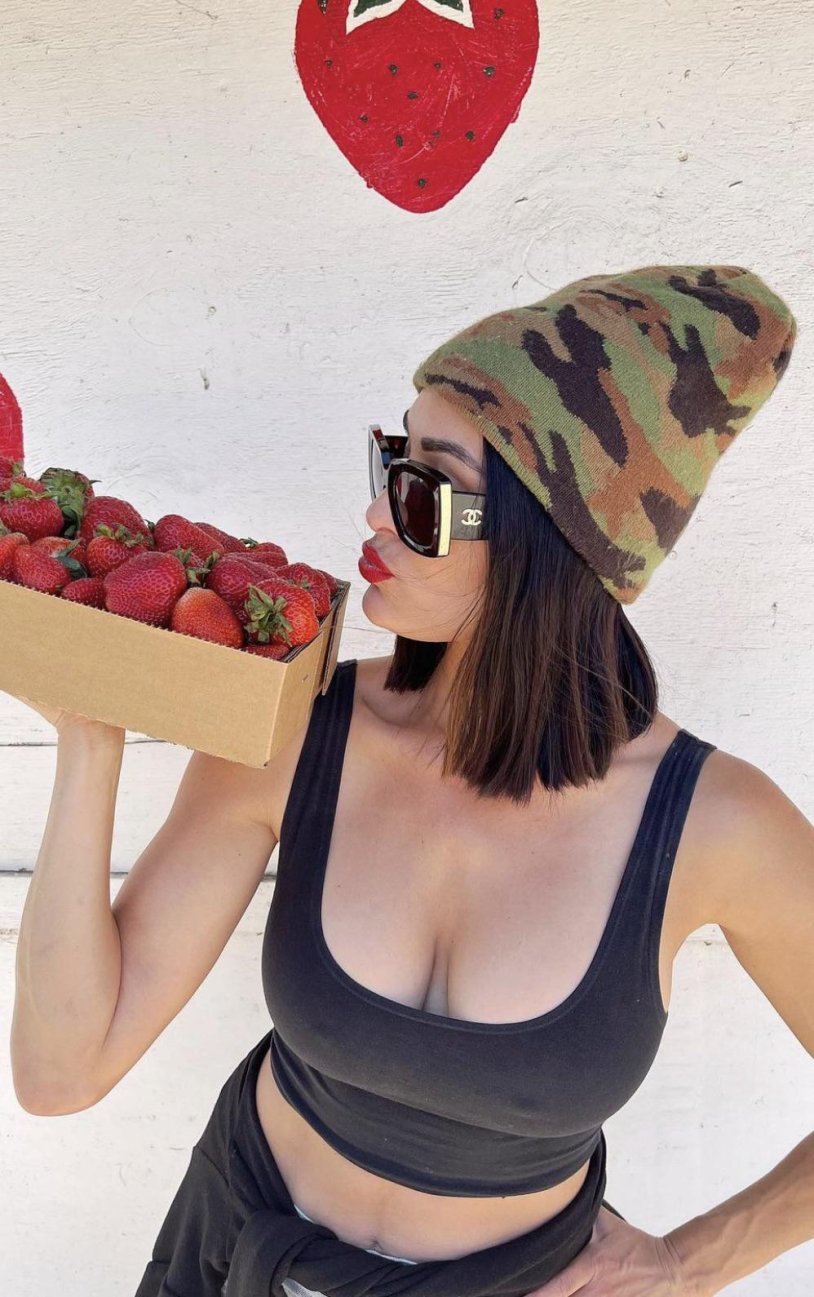 A man behind the woman holds the woman by the chest