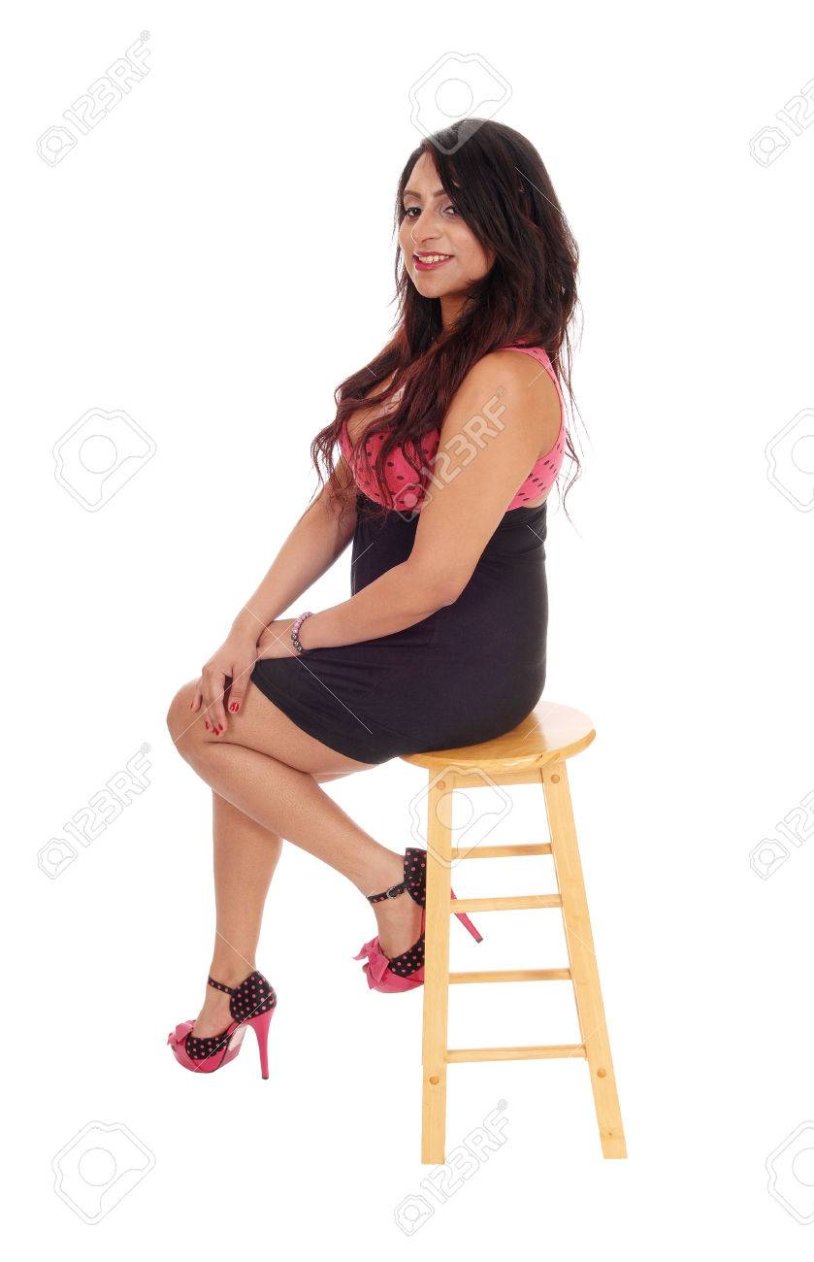 Girl in a sundress sits on a chair