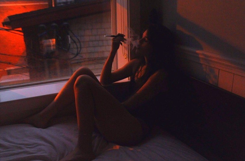 The girl smokes in the dark