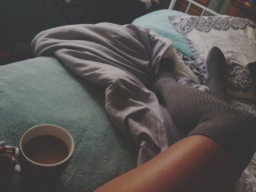 Legs in bed with a mug