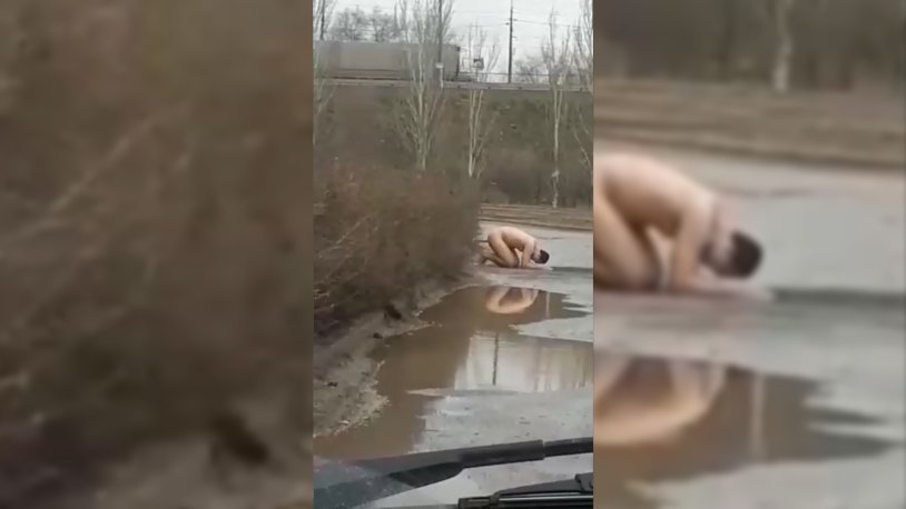 Woman bathes in a puddle
