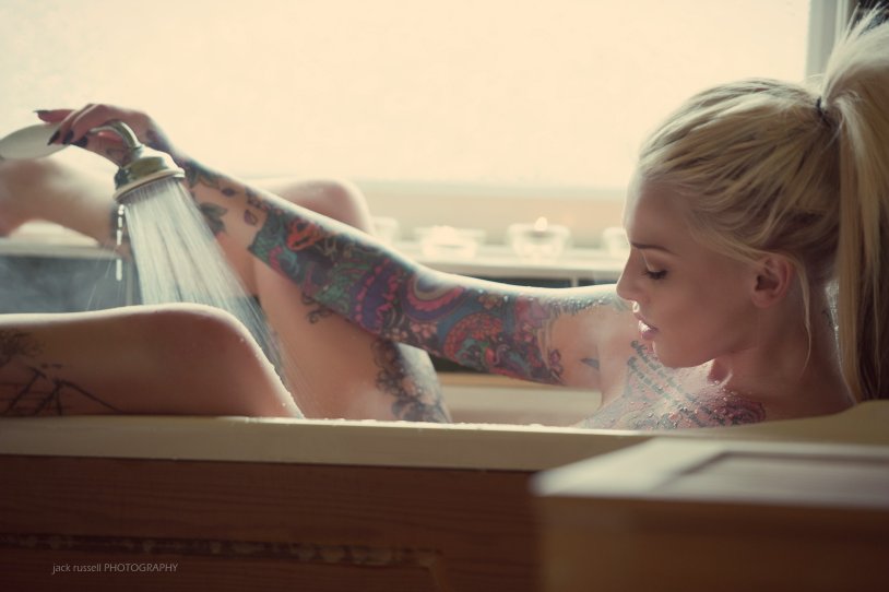 Girl with a tattoo in a bath