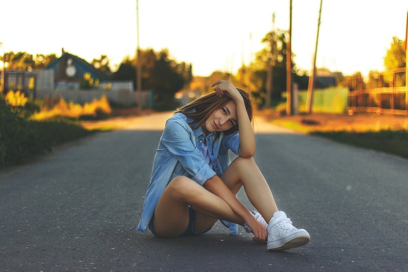 Girl sits on the asphalt
