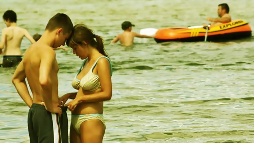 A girl looks into a guy's pants