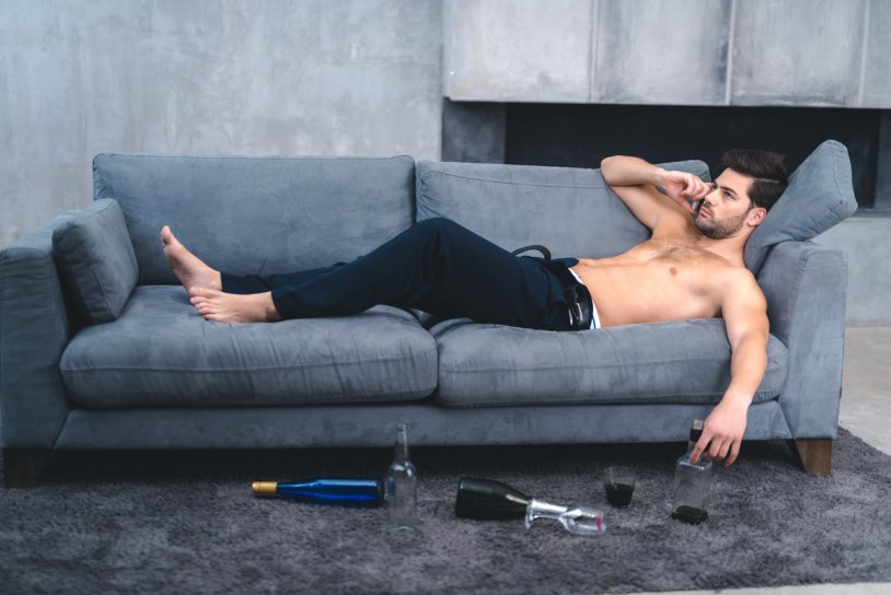 The man lies on the couch