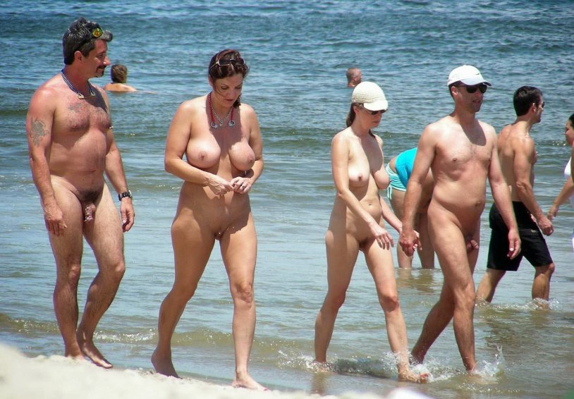 Naked people of different ages on the beach